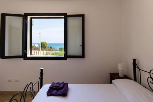 1 Schlafzimmer mit 2 Betten und einem Fenster in der Unterkunft ~ Villa Demetra ~ in Noto Marina