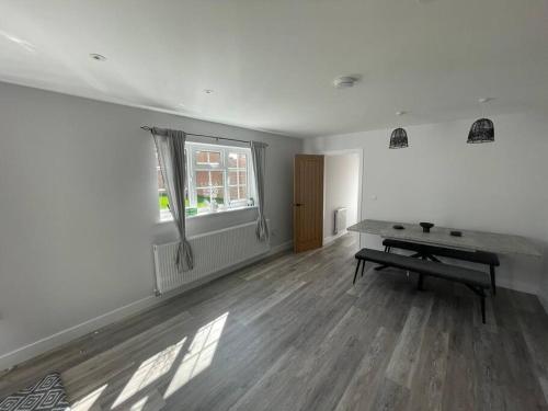 an empty room with a table and a window at DaisyChain Getaways at Chaney Rd in Wivenhoe