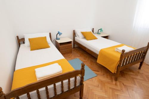 - 2 lits dans une chambre dotée de parquet dans l'établissement Piano Apartment, à Šibenik