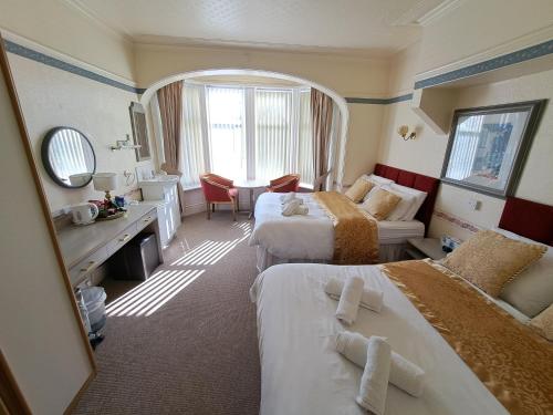 a hotel room with two beds and a table at Lily Hotel in Blackpool