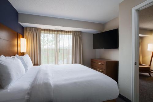 Cette chambre comprend un lit blanc et une télévision. dans l'établissement Residence Inn Columbia MD, à Ellicott City