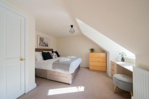 a white bedroom with a bed and a staircase at Seaside Home in Stonehaven, Aberdeenshire in Stonehaven