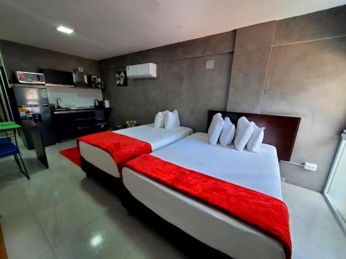 a hotel room with two beds and a kitchen at Bellini Suites Apartments in Santa Cruz de la Sierra