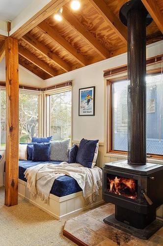 a bedroom with a bed and a fireplace in a room at HAY SHED Chalet, alpine-getaways in Dinner Plain
