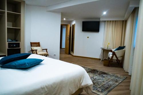 a hotel room with a bed and a television at Loureiro B&B in São Pedro do Sul