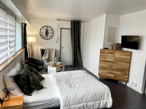 ein Schlafzimmer mit einem Bett und einer Uhr an der Wand in der Unterkunft Charmant Appartement Vannes Centre 30m2 in Vannes