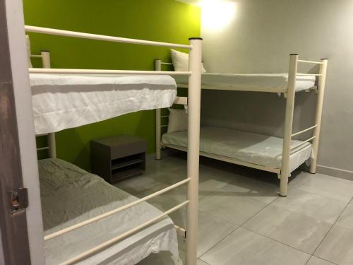 a room with three bunk beds and a green wall at Hotel HC Express in Monterrey