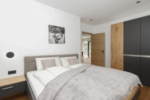 a bedroom with a large bed with white sheets at Justina 7 Apartments in San Paolo