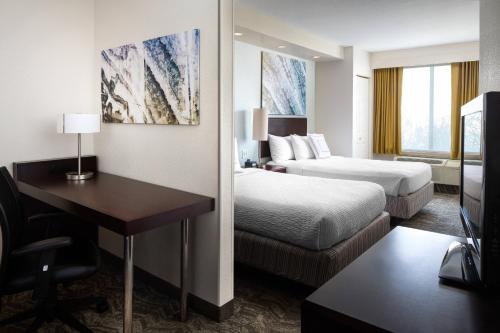 a hotel room with two beds and a desk and a desk at SpringHill Suites Bakersfield in Bakersfield