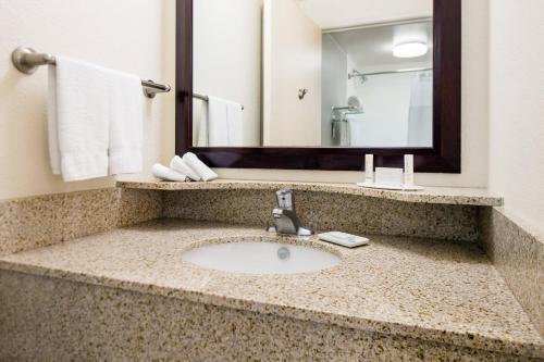 SpringHill Suites Bakersfield في بيكرسفيلد: حمام مع حوض ومرآة