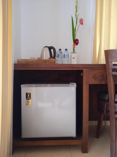 a desk with a white refrigerator under a table at Tanah Semujan Ubud in Ubud