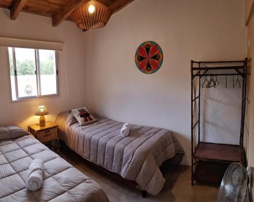 a bedroom with two beds and a clock on the wall at Malvón in Cafayate