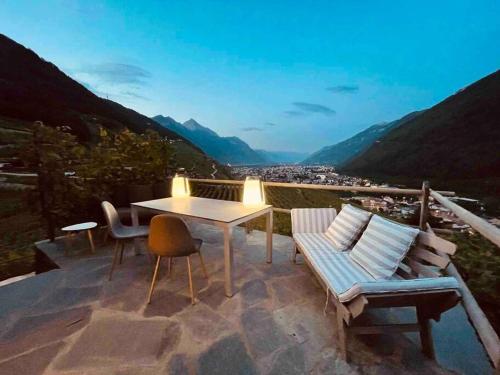 a patio with a table and chairs and a view at Magnifique Mazot Dans Les Vignes in Martigny-Combe