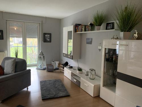 un soggiorno con divano e frigorifero di Wohlfühlferienwohnung mit Terrasse in Bensberg a Bergisch Gladbach