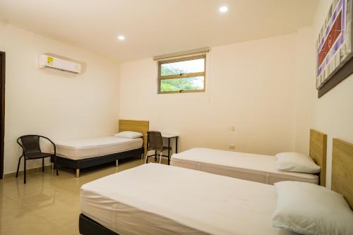 a hospital room with three beds and a window at Genesis Hotel in Sincelejo