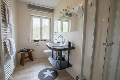 La salle de bains est pourvue d'un lavabo et d'une douche. dans l'établissement Ferienwohnung Steinrose, à Füssen
