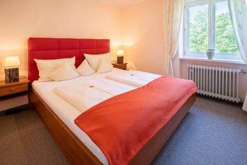 een slaapkamer met een groot bed met een rood hoofdeinde bij Ferienwohnung Edelweiss in Füssen