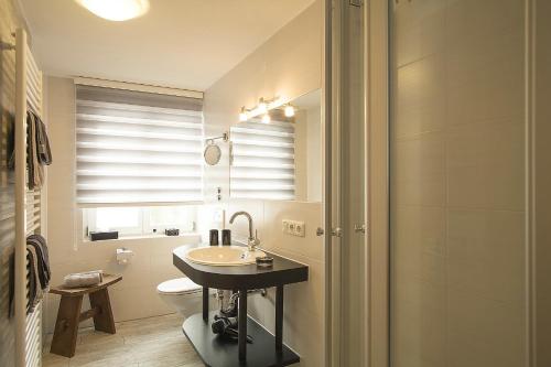 een badkamer met een wastafel, een toilet en een raam bij Ferienwohnung Edelweiss in Füssen