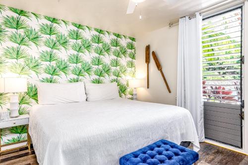 1 dormitorio con 1 cama con papel pintado tropical en Kona Bali Kai #174, en Kailua-Kona