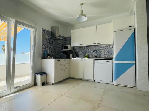 Il comprend une cuisine équipée d'appareils électroménagers blancs et une grande fenêtre. dans l'établissement La Terraza, à Playa Blanca