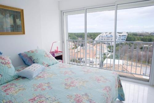 une chambre avec un lit et une grande fenêtre dans l'établissement * Le Rêve Bleu * Vue Mer *, à La Grande Motte