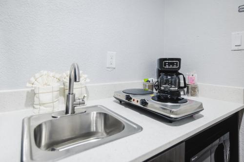 a kitchen counter with a sink and a coffee maker at Studio 6 Channelview TX Baytown West in Channelview