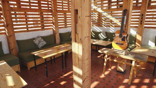 a room with benches and a guitar in a restaurant at Cozy Surf House in Taghazout