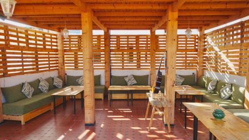 a restaurant with benches and tables in a wooden structure at Cozy Surf House in Taghazout
