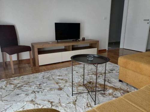 a living room with a table and a television at Apartman Nomino in Zvornik