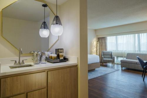 a hotel room with a sink and a mirror at The Westin O'Hare in Rosemont