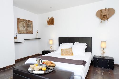 a hotel room with a bed and a tray of food on a table at De la suite dans les oliviers in Gallargues-Le-Montueux