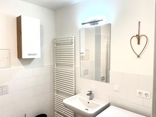 a white bathroom with a sink and a mirror at 55m2 Modern Flat with Balcony in Vienna