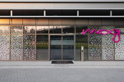 a building with a pink sign on the side of it at Moxy Cologne Bonn Airport in Cologne