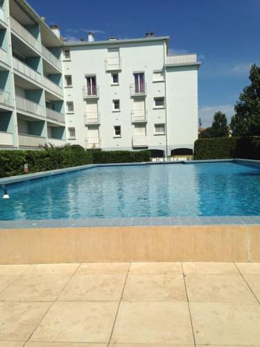 une grande piscine devant un immeuble dans l'établissement Appartement pas cher en Bord de mer avec Piscine, à Canet