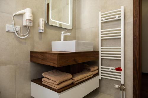 W łazience znajduje się umywalka, lustro i ręczniki. w obiekcie Edemus - Motel & Restaurant w mieście Maglaj