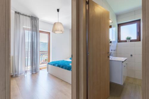 a bedroom with a bed and a bathroom with a window at Apartments with parking space Rabac, Labin - 3011 in Rabac