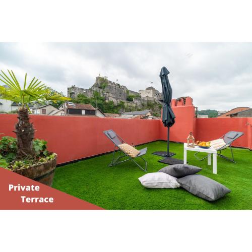 - un jardin sur le toit avec une table, des chaises et un parasol dans l'établissement Air-conditioned flat with terrace - Private & independent - Lourdes, à Lourdes