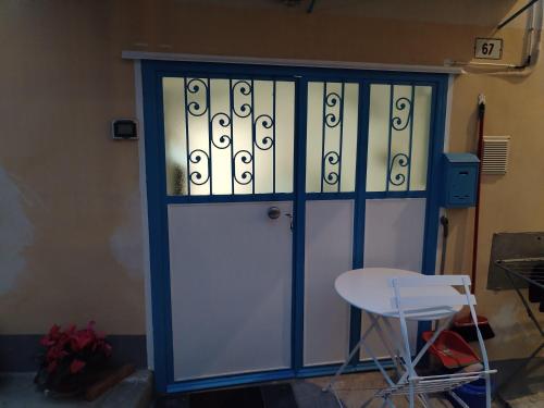 a blue and white door with a chair and a table at La tavernetta del Peo casa vacanze in Sanremo