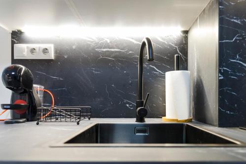 een aanrecht met een kraan en een rol papieren handdoeken bij El rinconcito de la playa, parking incluido in Sanxenxo