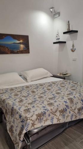 a bed in a white room with a blanket on it at La piccola Perla in Savona
