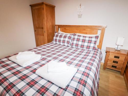 a bedroom with a bed with two towels on it at Watersview Lodge in Leek