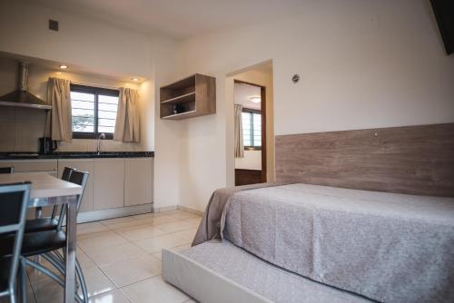 a bedroom with a large bed and a kitchen at Altos del Champaqui in Villa Carlos Paz