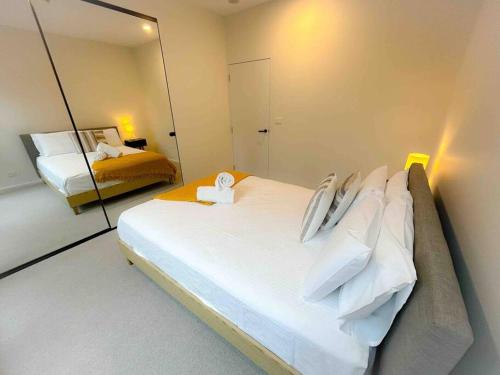 a bedroom with a large bed and a mirror at Moonee Ponds Living on Young - 205 in Melbourne