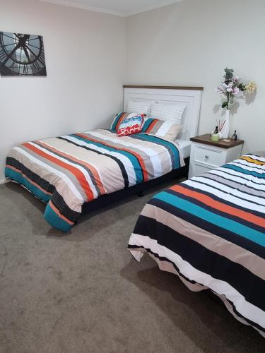 two beds sitting next to each other in a bedroom at 1 bdrm Beach Apartment Papamoa in Papamoa