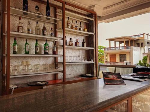 - un bar avec des bouteilles et des verres sur le mur dans l'établissement HÔTEL NOAHGARDEN 2, à Cotonou