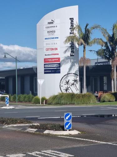 a sign on the side of a road in front of a building at Little Gem in Papamoa in Papamoa