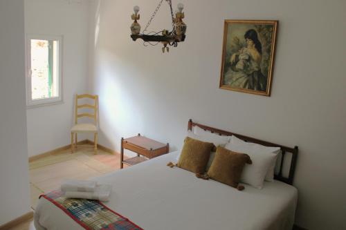 a bedroom with a bed and a painting on the wall at Casa da Vó Matilde 