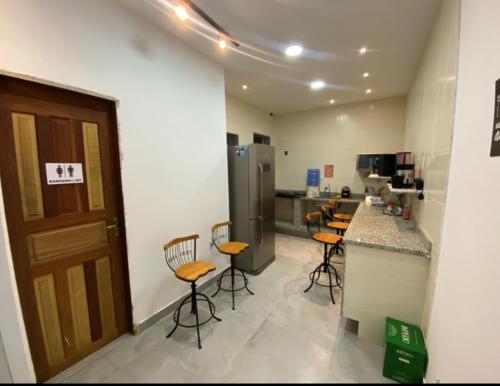 uma cozinha com um balcão e bancos num quarto em valenshostel em Angra dos Reis