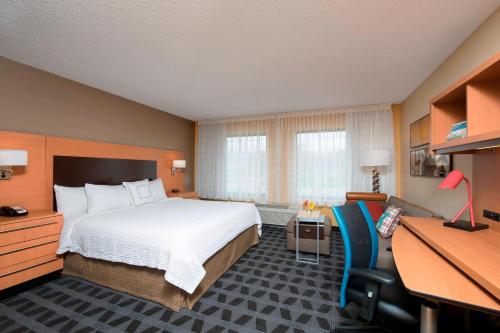 a hotel room with a bed and a desk at TownePlace Suites by Marriott Kalamazoo in Portage