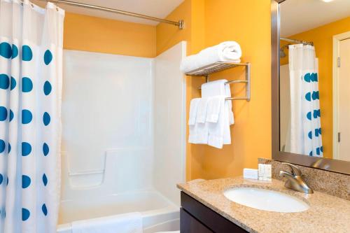 y baño con lavabo, ducha y bañera. en TownePlace Suites by Marriott Kalamazoo, en Portage